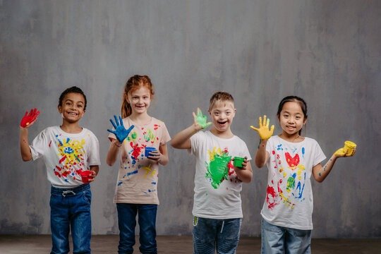 Happy children with painted hands in an inclusive and joyful developmental therapy session